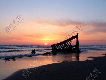 海滩沉船夕阳图片