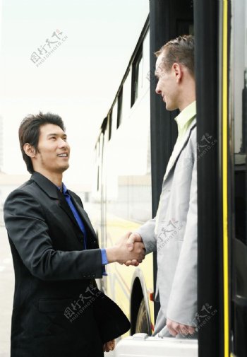 公交车门口见面握手的商务人物图片