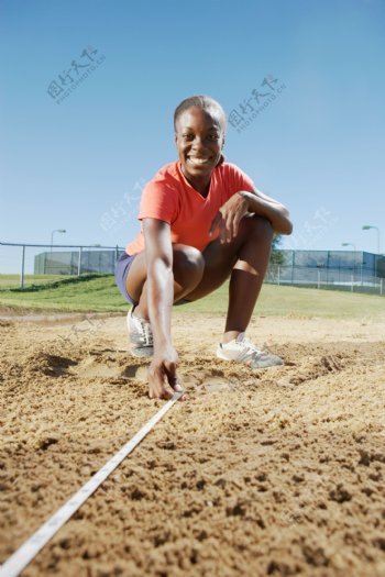 测量沙坑的女性运动员高清图片