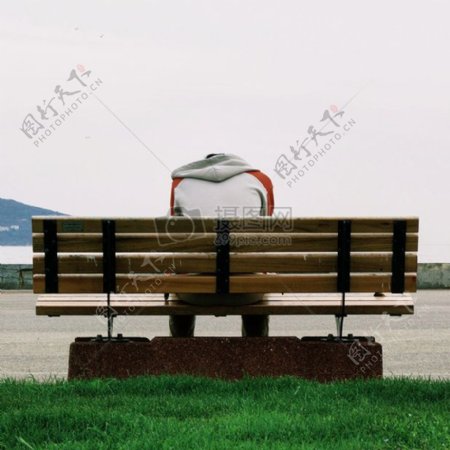 人穿着灰色和橙色连帽衫白天布朗木制长凳公园坐