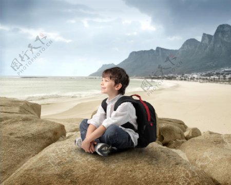 坐在岩石上的外国男孩图片