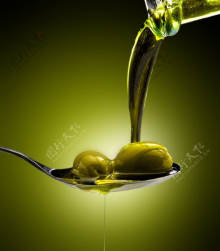 倒在勺子上的橄榄油和橄榄图片