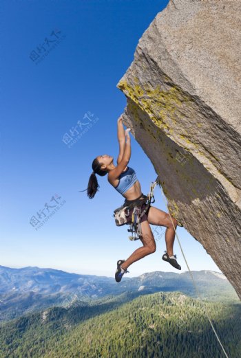 攀登石头的女运动员图片