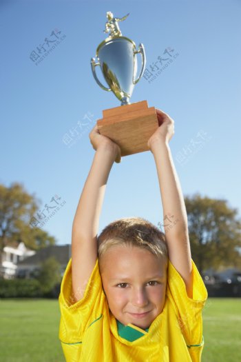 举起奖杯的男孩图片