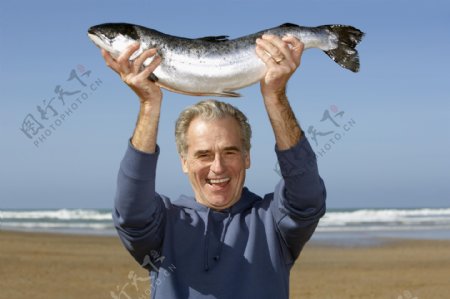 沙滩抓鱼的老人图片
