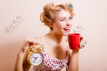提着闹钟喝咖啡的女人图片
