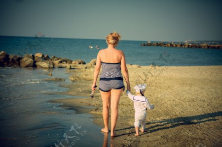 海滩散步的母子图片