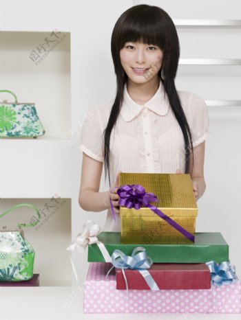 漂亮女孩拿着许多礼品盒图片