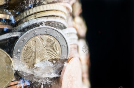 有光泽的欧元硬币冻结在冰前德国硬币