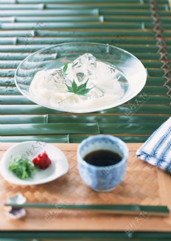 绿色桌子上玻璃盘里的冰水高清图片下载