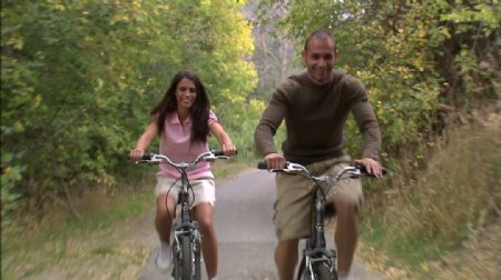 夫妇骑自行车通过树覆盖的道路7股票的录像视频免费下载