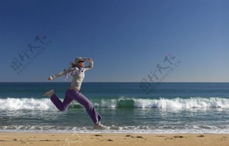海边奔跑的年轻女人图片