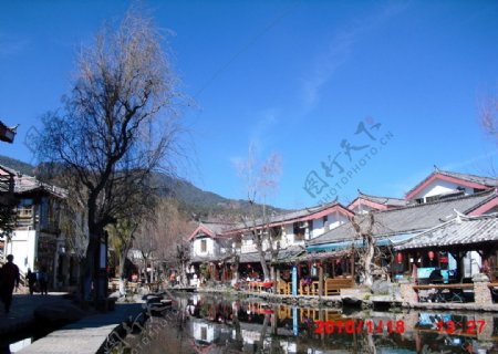 丽江束河古镇镇中心有一个池塘周边是餐馆酒吧图片