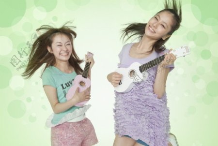 两个弹吉他跳跃的女孩图片