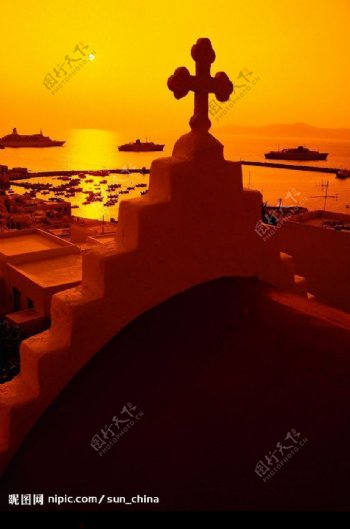 欧洲海岸夕阳下金黄的十字架图片