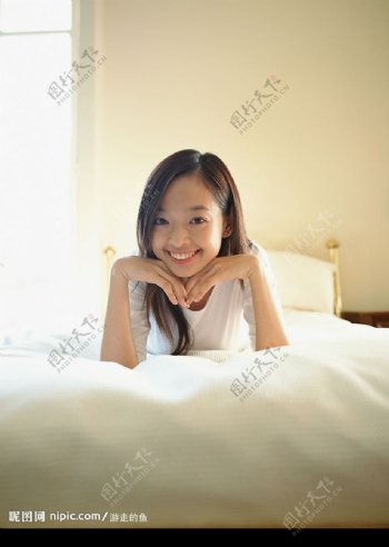 床上微笑的女孩儿图片