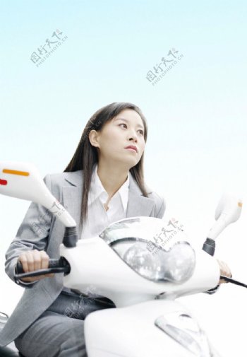 骑电动自行车的商务美女图片