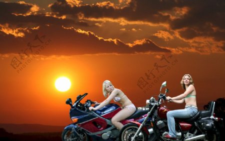 日出下的女摩托车手图片