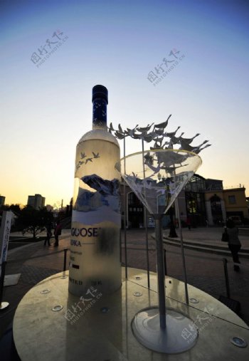 夕阳下酒杯与酒瓶雕塑图片