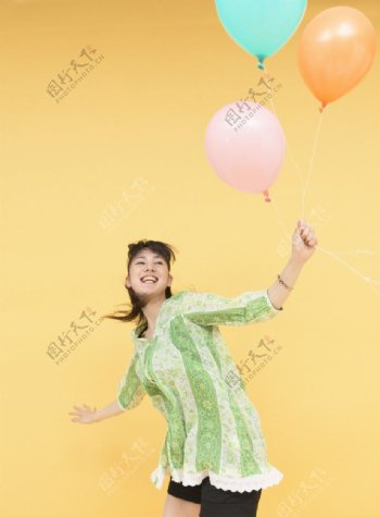 拿着彩色气球的快乐女大学生图片