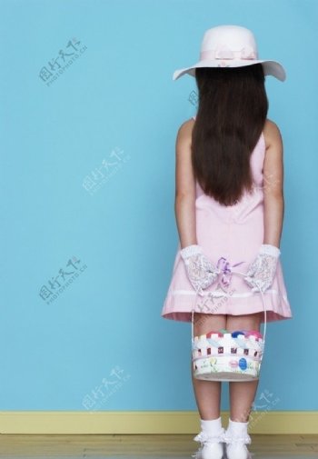 面对墙站着背手拿着小篮子的小女孩图片