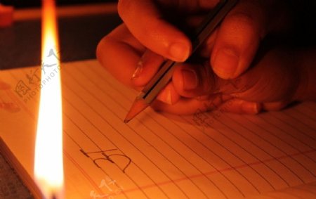 小学生在烛光下写字图片