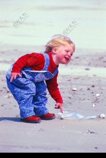 沙滩上捡塑料瓶的小女孩图片