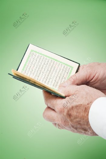 手拿可兰经的人图片