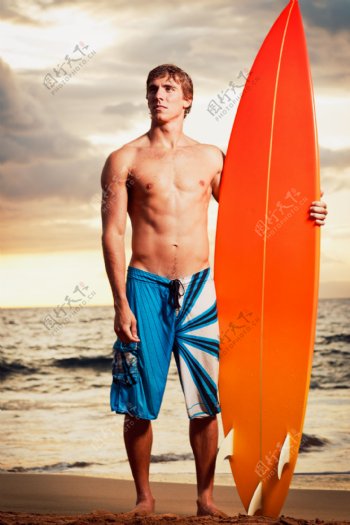 沙滩上的男人和冲浪板图片