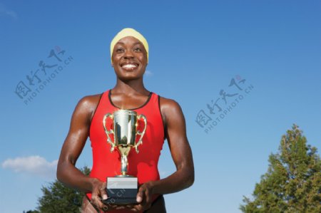 手捧奖杯的黑人女性运动员图片