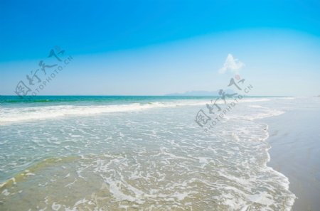 冲向岸边沙滩的海浪图片