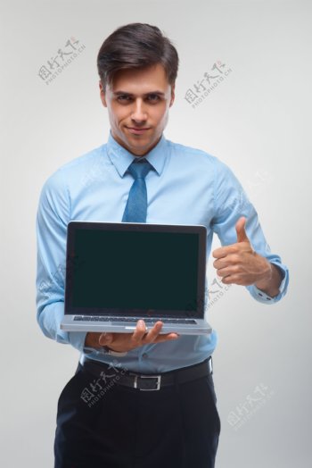 拿着电脑竖起大拇指的男人图片