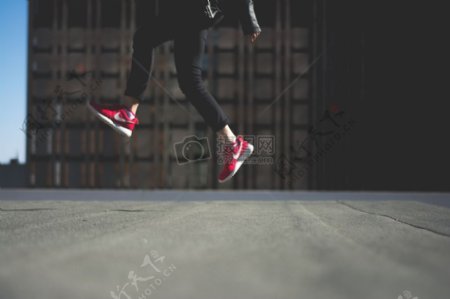 人类在黑色运动长裤随着红色耐克运动鞋跳