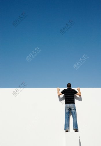 站在立方体上向上望的男人背影图片