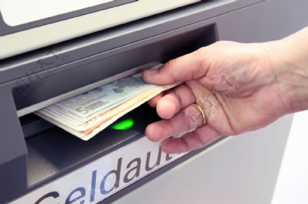从ATM里取钱的手图片