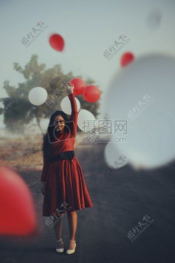 女子在红色礼服迷笛拿着气球