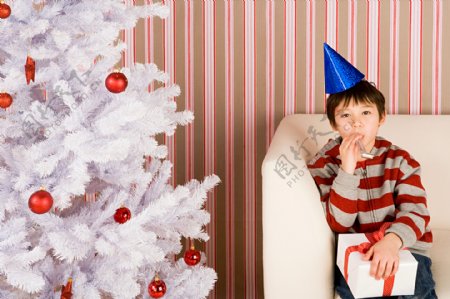 圣诞树边上的小男孩图片