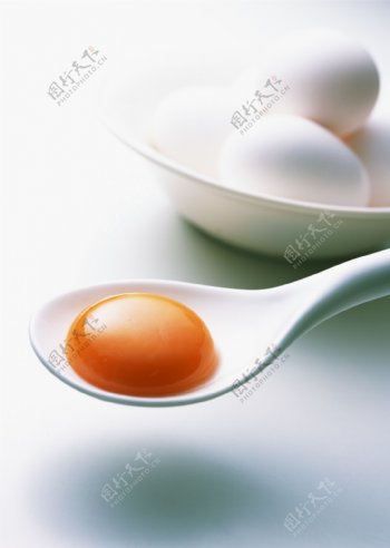 勺子里的蛋黄摄影图片