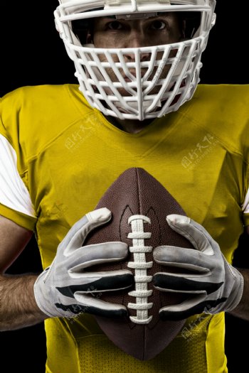 双手握着球的橄榄球运动员图片