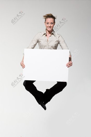 跳起双手拿白纸的女人图片