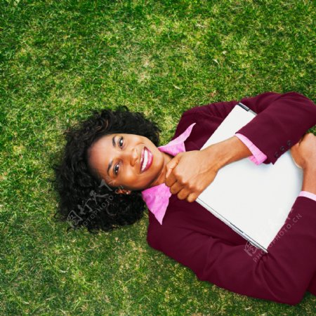 躺在草地上的商务女性图片