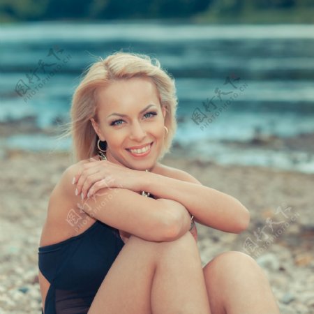 坐在沙石上的性感美女图片