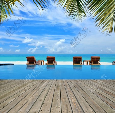 夏季的游泳池与沙滩椅图片