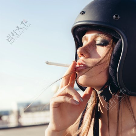 戴着头盔的吸烟女人图片