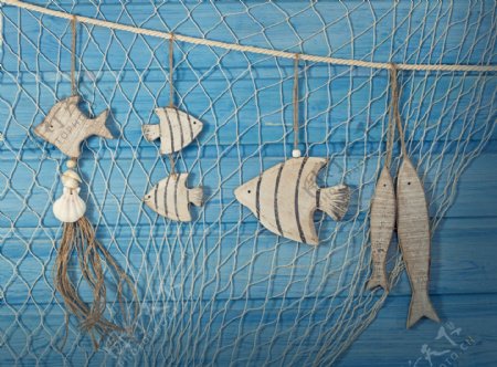 蓝色木板前的渔网和鱼图片