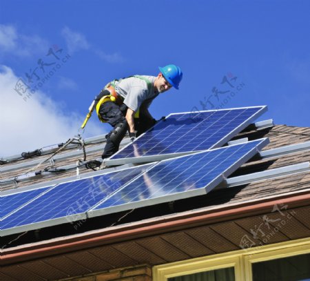 房顶安装太阳能电池板的工人图片