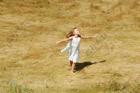 草地上玩耍的小女孩图片