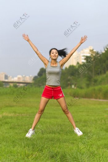 正在草地上跳操的女孩图片