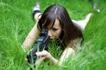 趴在草地上射击的女人图片