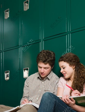 靠着柜子坐着做作业的外国情侣图片